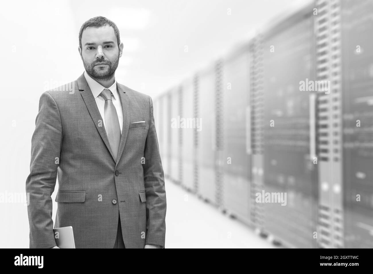 Portrait of young businessman in server room using tablet Stock Photo