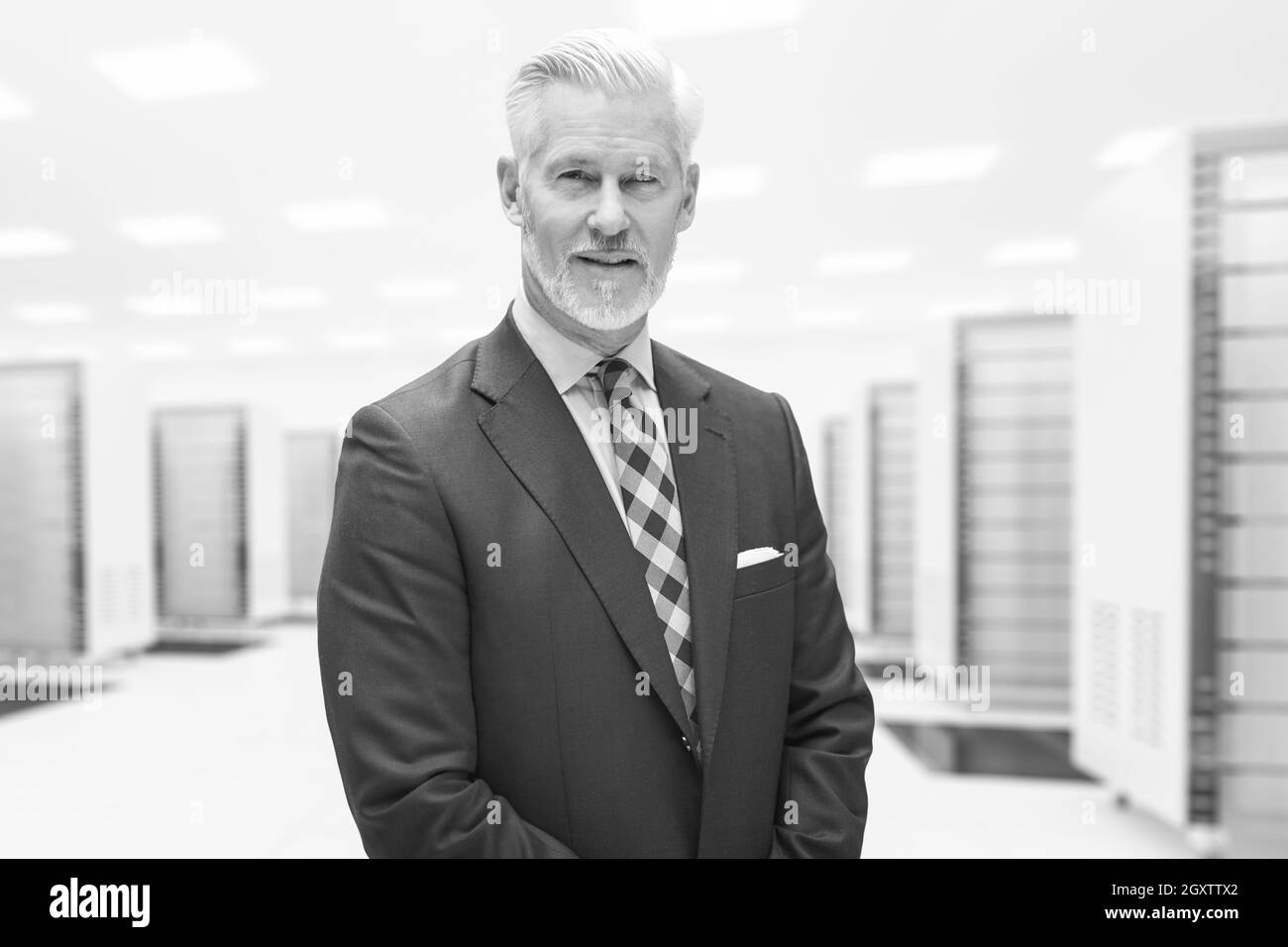 Portrait of senior businessman in big rack server room Stock Photo