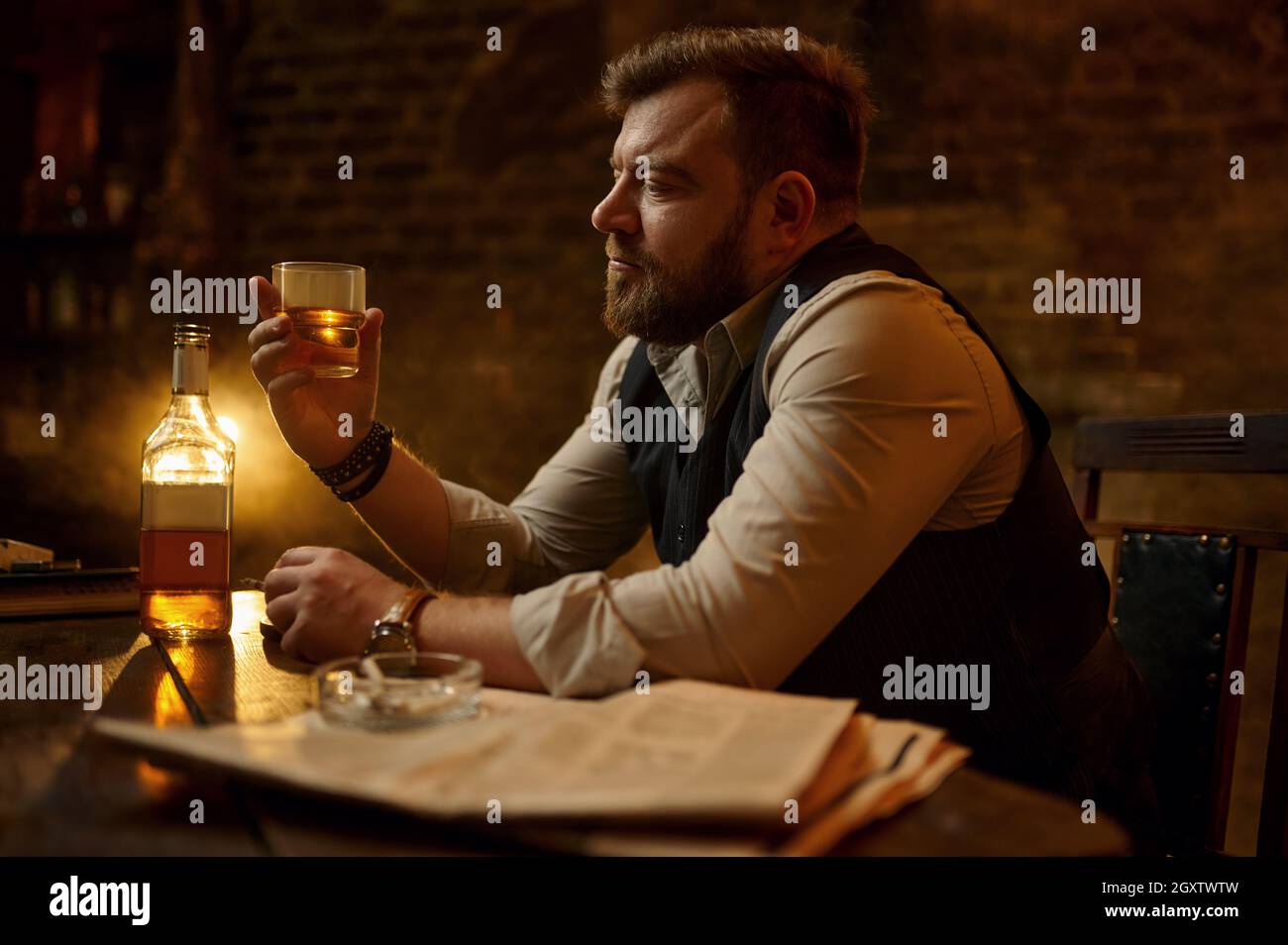 Businessman smokes cigarette and drinks alcohol beverage, vintage office  interior on background. Tobacco smoking culture, specific flavor. Male  smoker Stock Photo