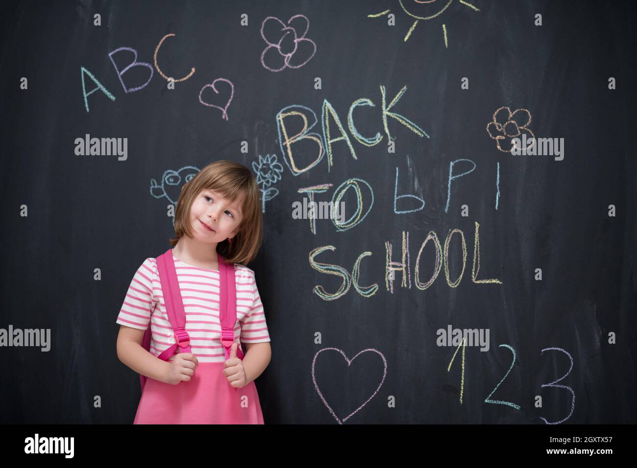 Happy school girl child with backpack writing back to school on black ...