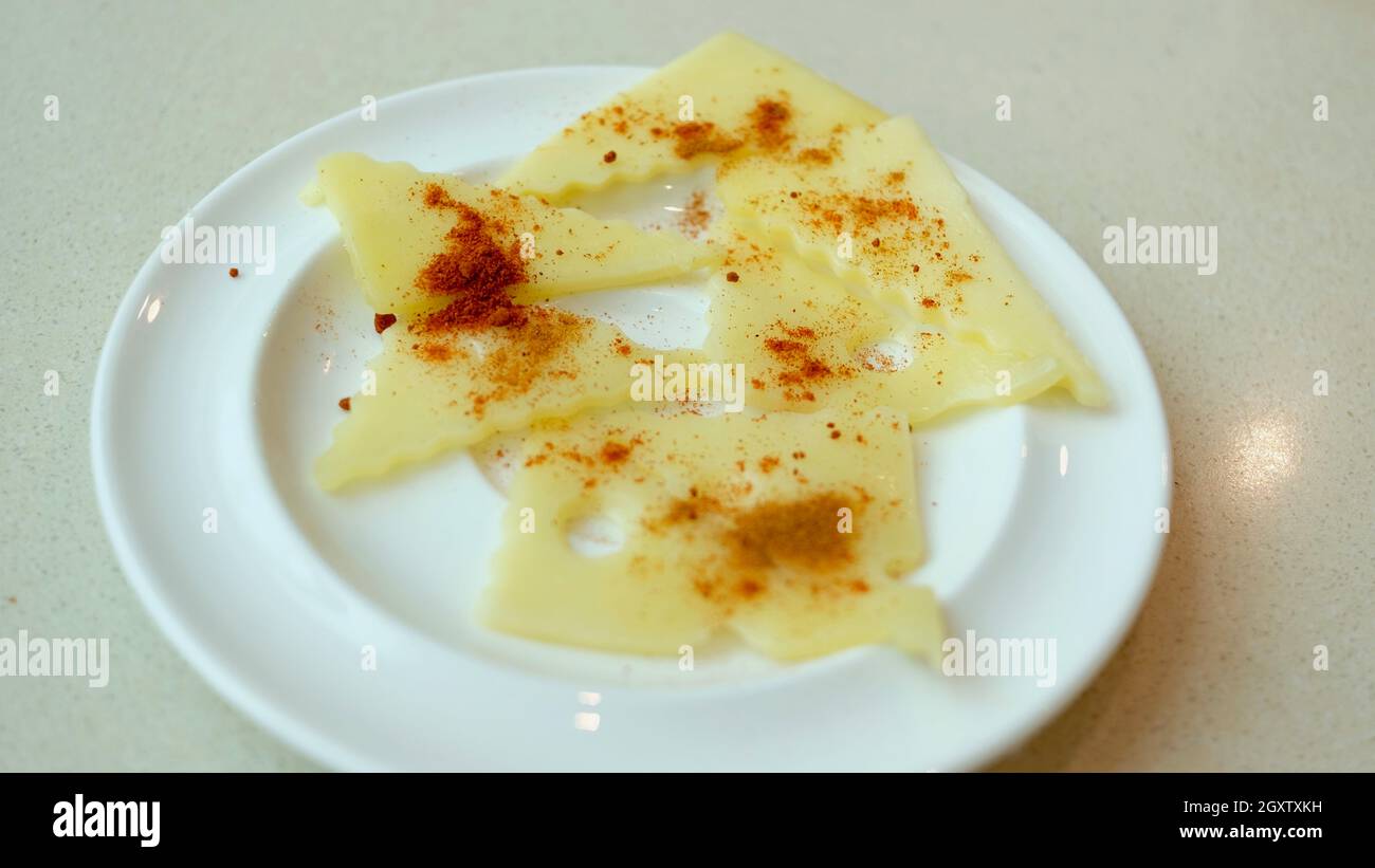 Swiss Serrated Cut Cheese Plate with Cayenne Red Pepper and Paprika Stock Photo