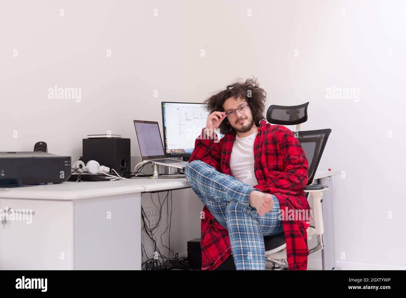 young graphic designer in bathrobe working at home office using computer Stock Photo