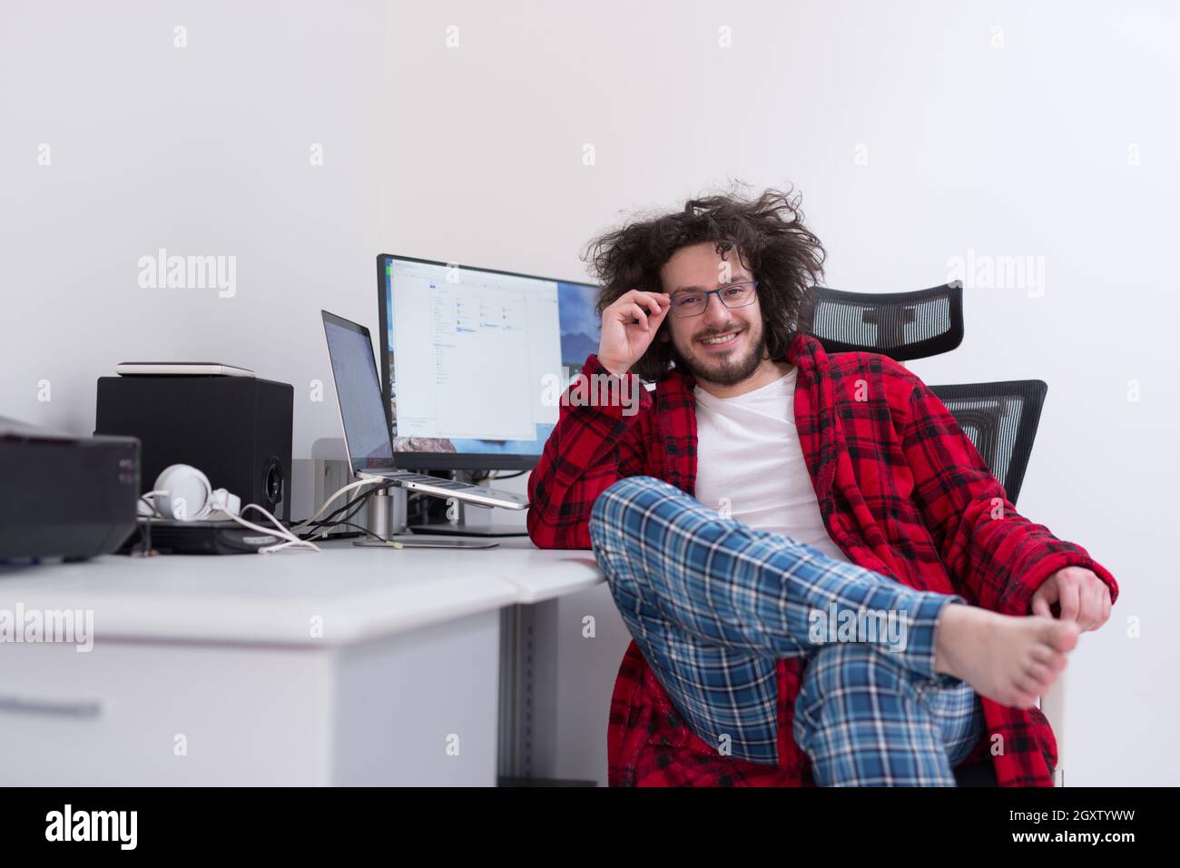 young graphic designer in bathrobe working at home office using computer Stock Photo