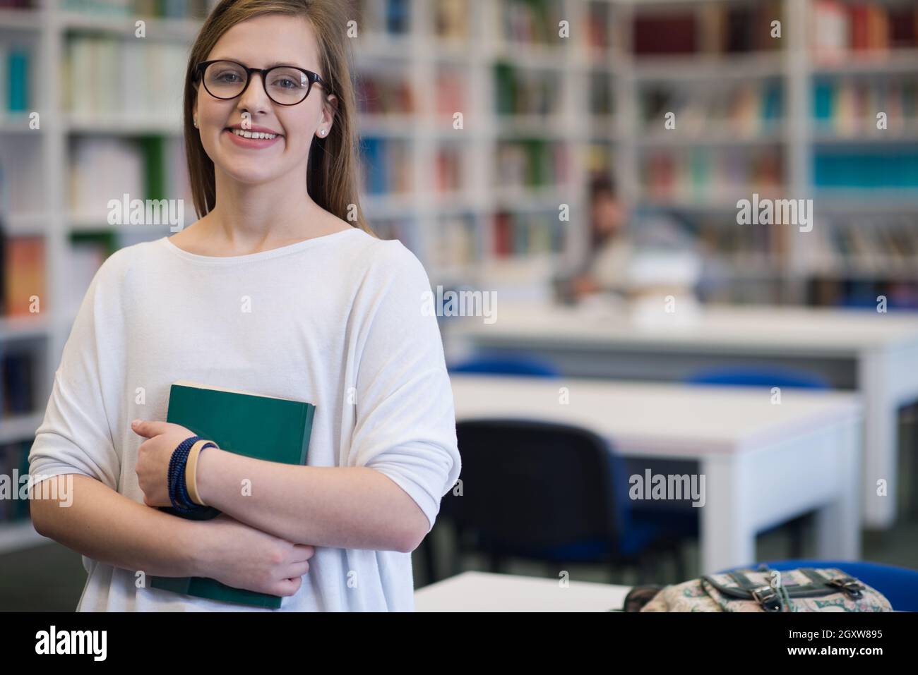 portrait of happy smilling female student girl in school library ...
