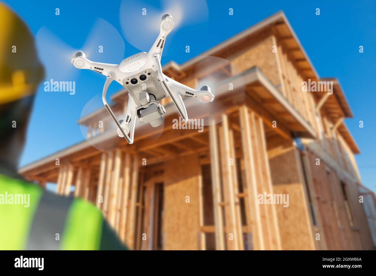 Pilot Flies Drone Quadcopter Inspecting Home Construction Site. Stock Photo