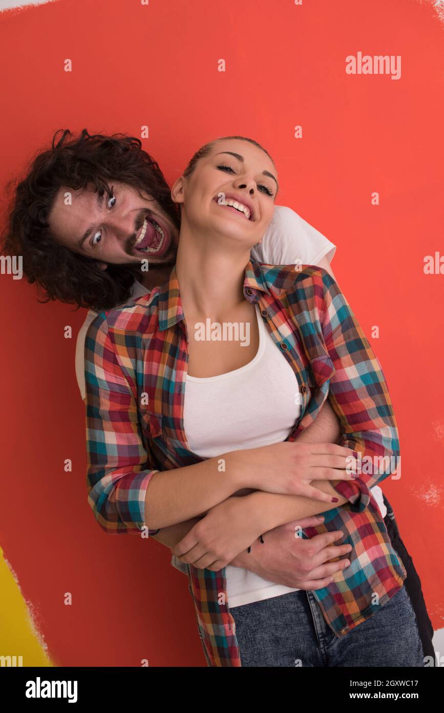 Portrait of a happy young smiling couple in love over color background ...