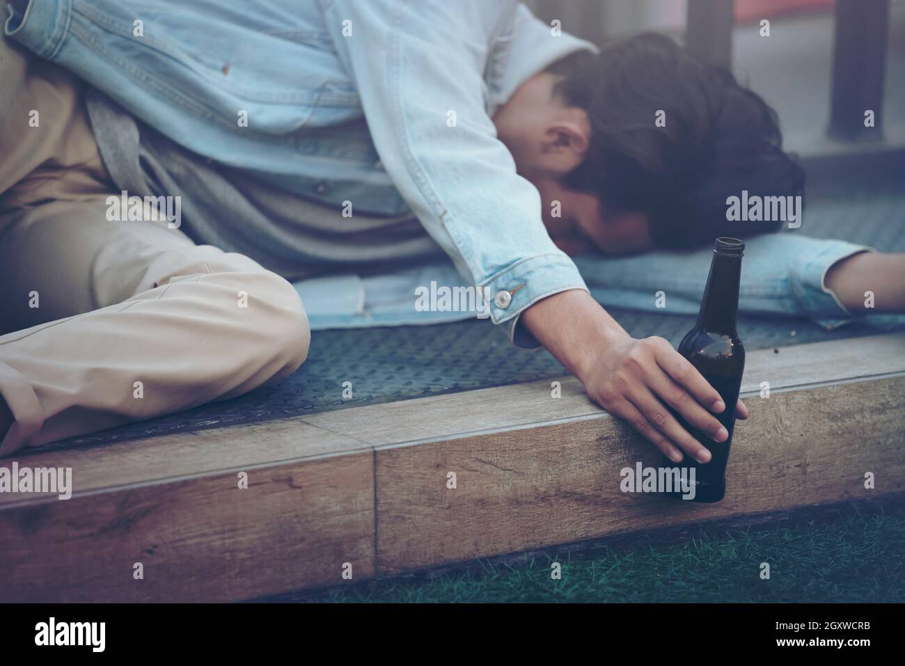 After party. Drunk bearded young man lying on the street sidewalk and