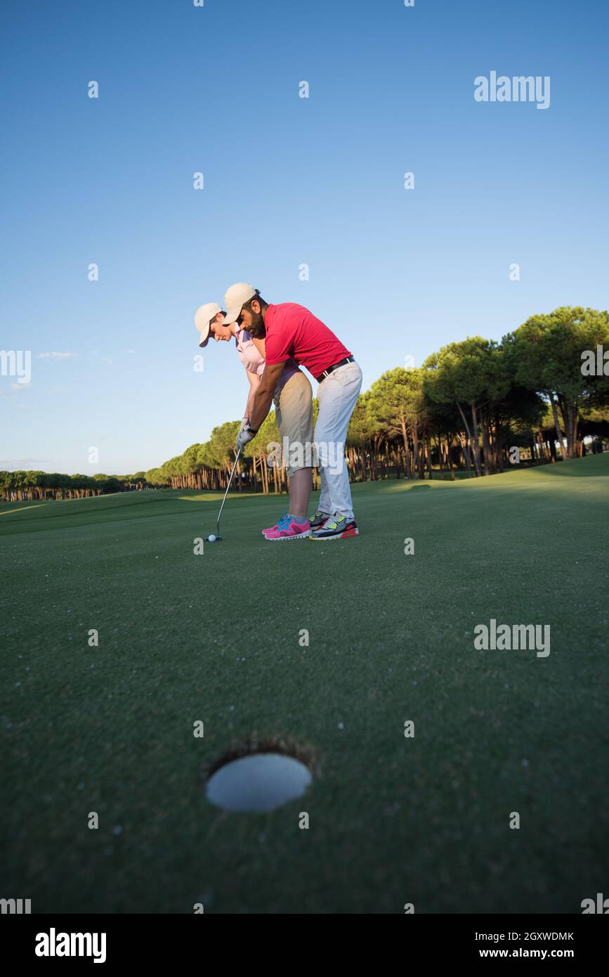 male golf instructor teaching female golf player, personal trainer