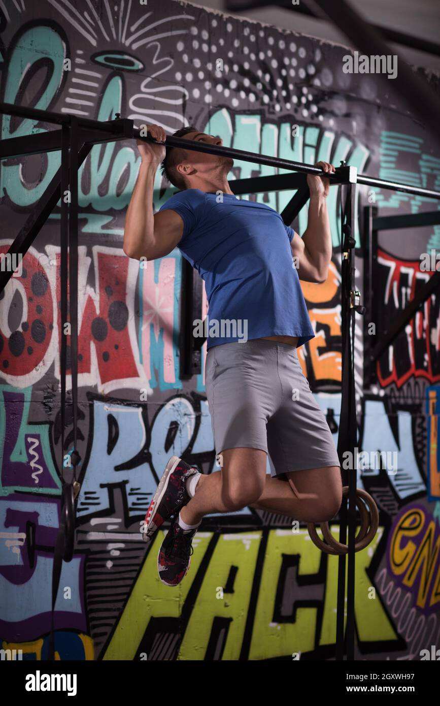 strong young man doing pull ups on a bar in a gym Stock Photo - Alamy
