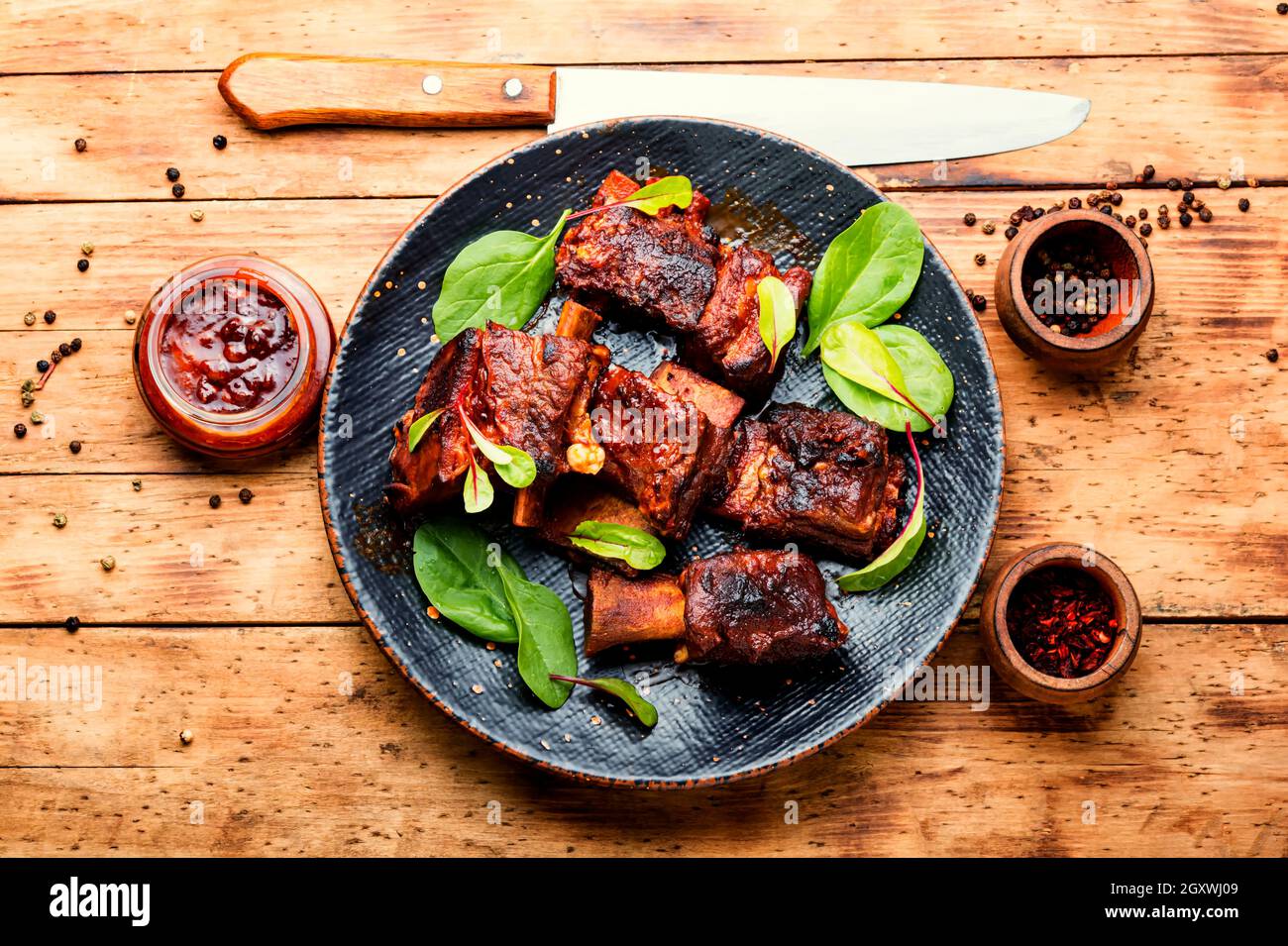 Spicy barbecue beef ribs with herb on rustic wooden table.BBQ beef rib