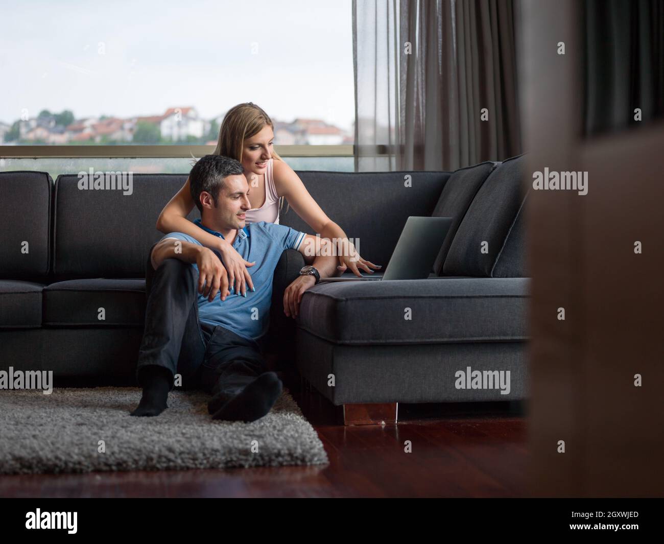 Attractive couple using a laptop in the living room Stock Photo