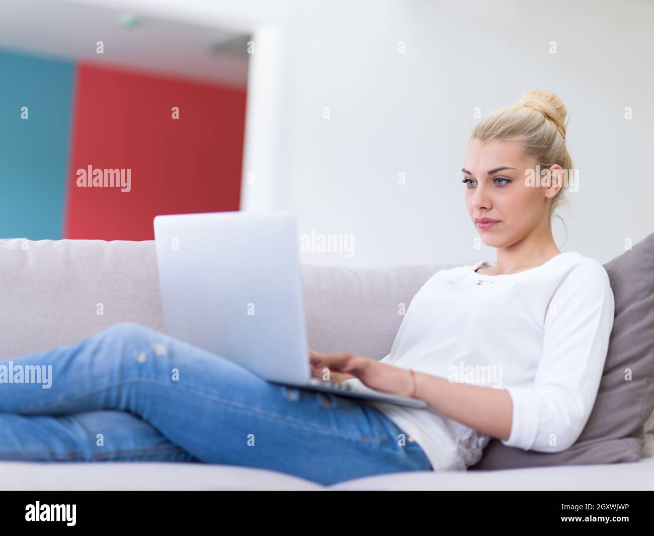 Young woman using her laptop computer in her luxury modern home ...