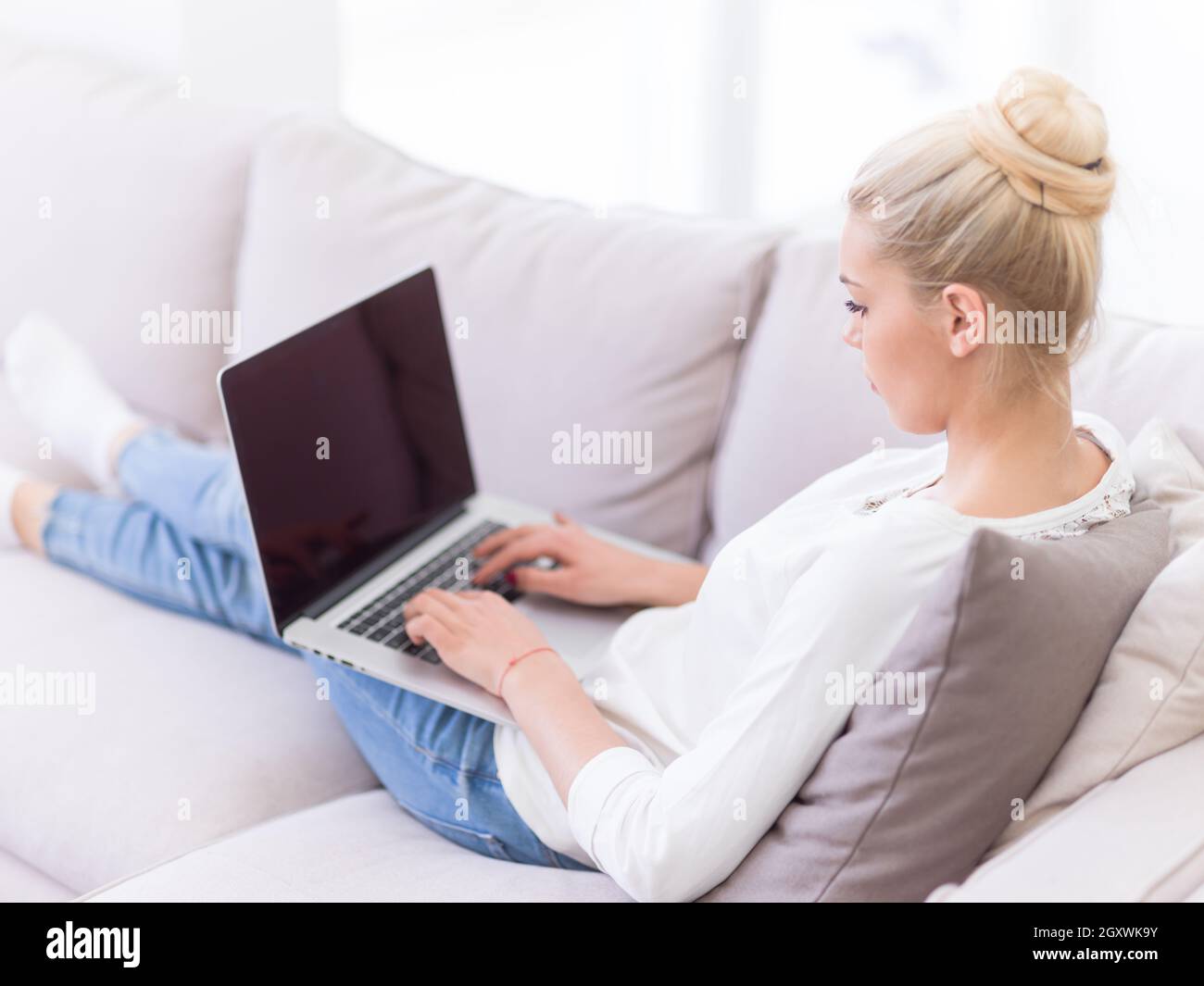 Young woman using her laptop computer in her luxury modern home ...