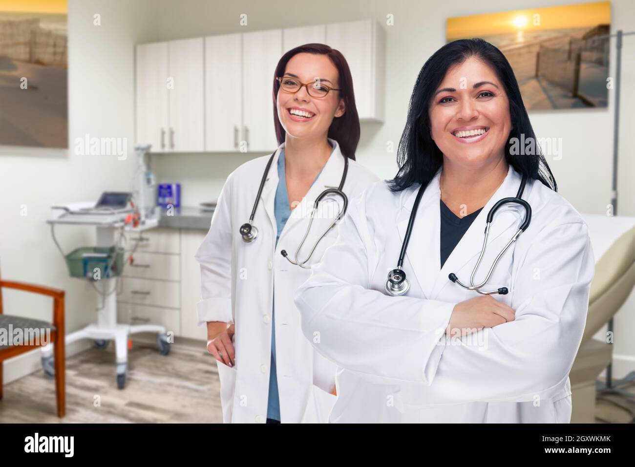 Hispanic and Caucasian Female Doctors Standing In Office. Stock Photo