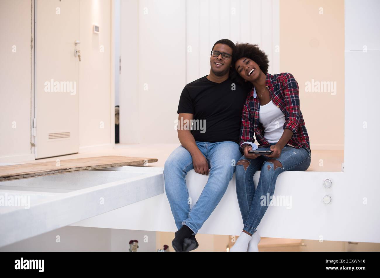 Happy young African American couple having break during moving to new ...