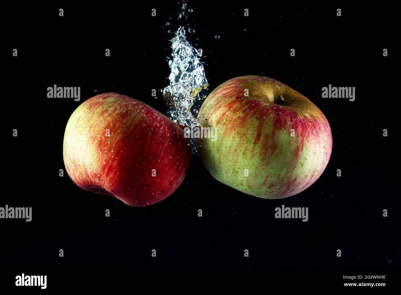 Two apples in water on a black background. Stock Photo