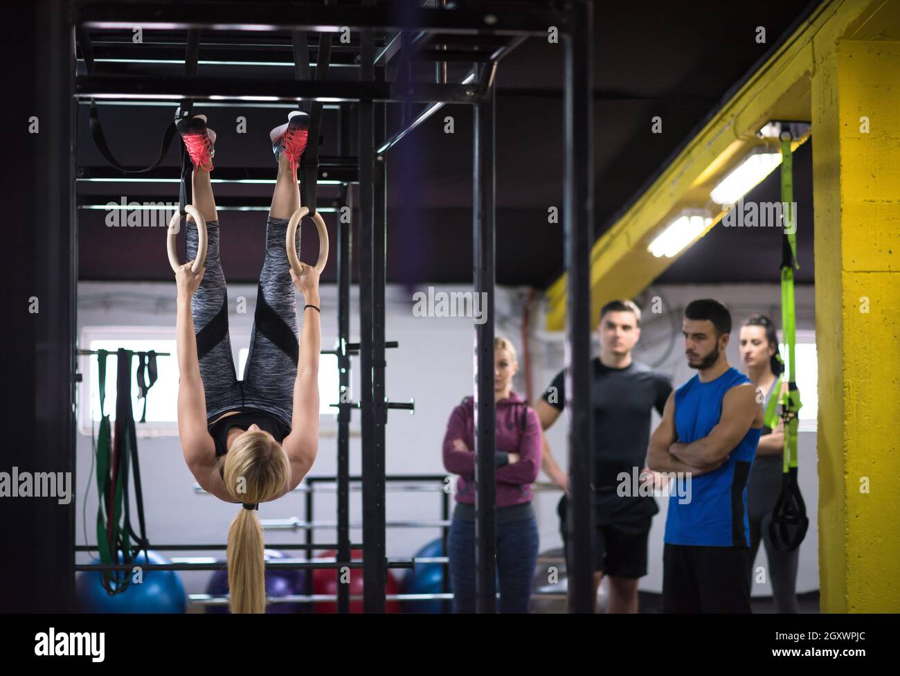 young athletic woman working out with personal trainer on gymnastic