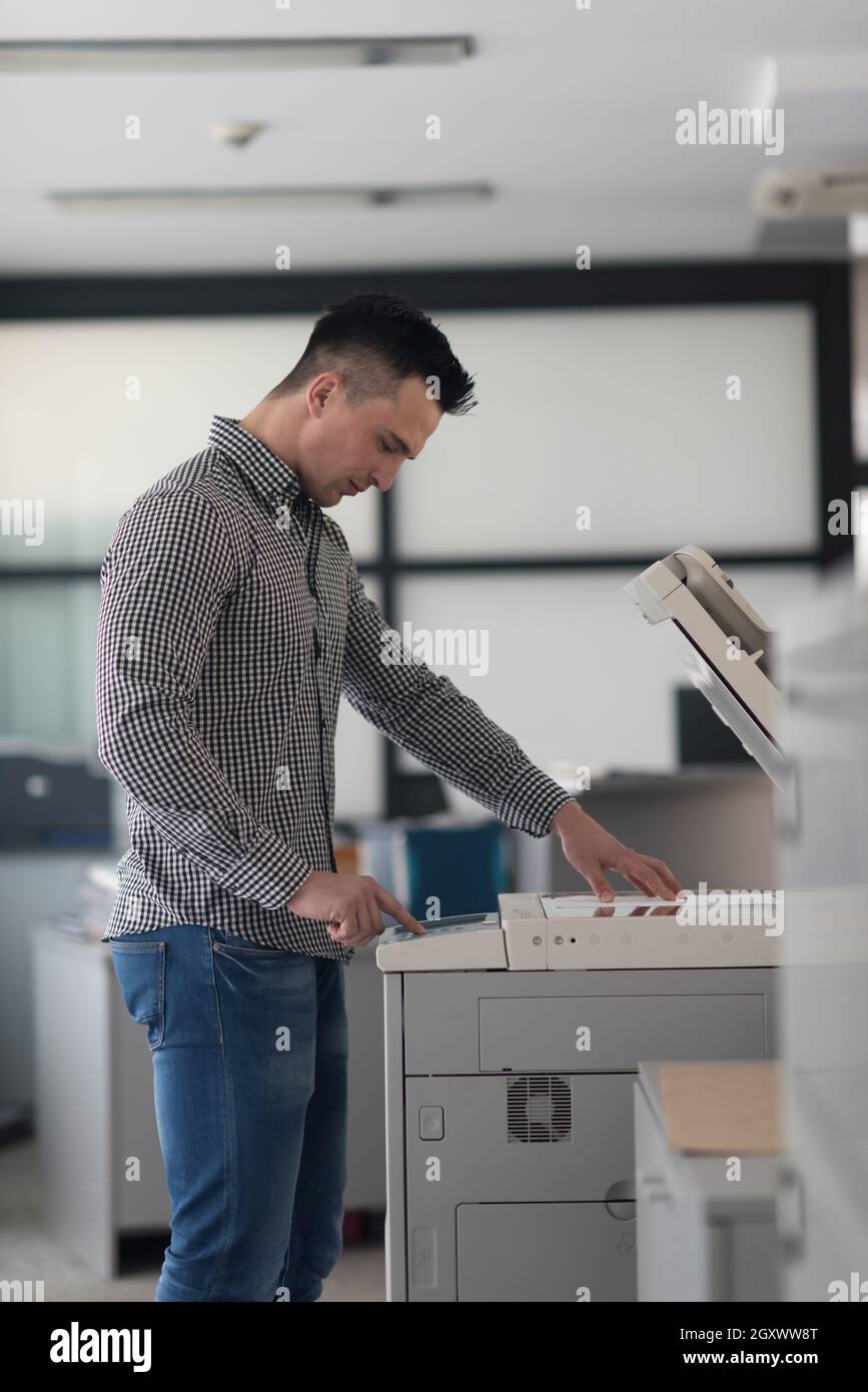 young business man copy documents on copy machine at modern startup office interior, casual clothes Stock Photo