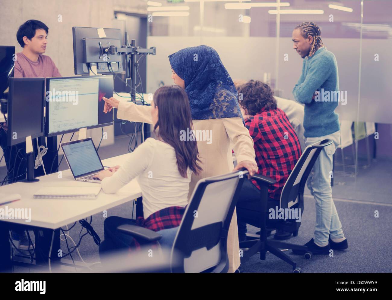 young multiethnics business team of software developers working together using laptop computer while writing programming code at modern startup office Stock Photo