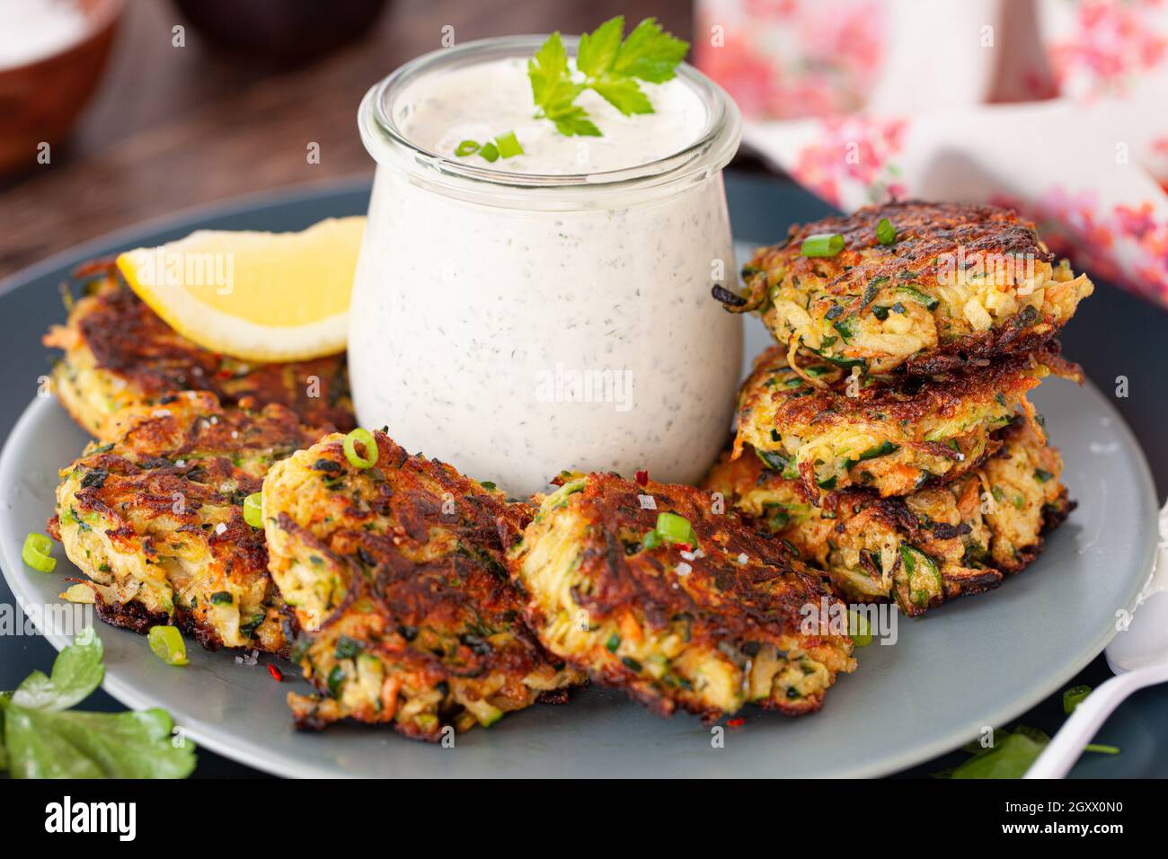 Savory zucchini vegetable fritters with a sour cream dip Stock Photo