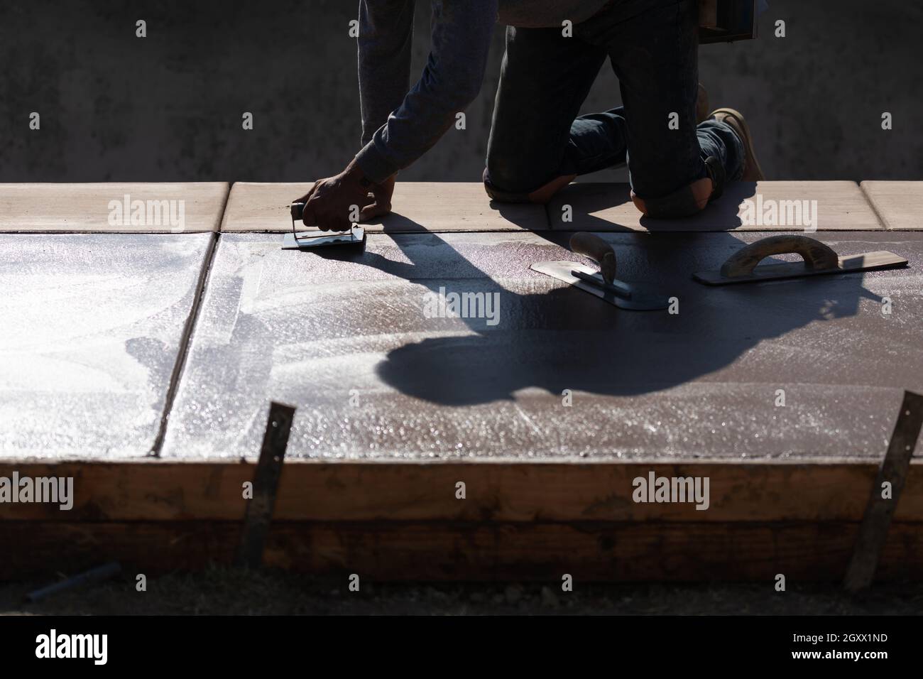 Construction Worker Smoothing Wet Cement With Hand Edger Tool Stock Photo