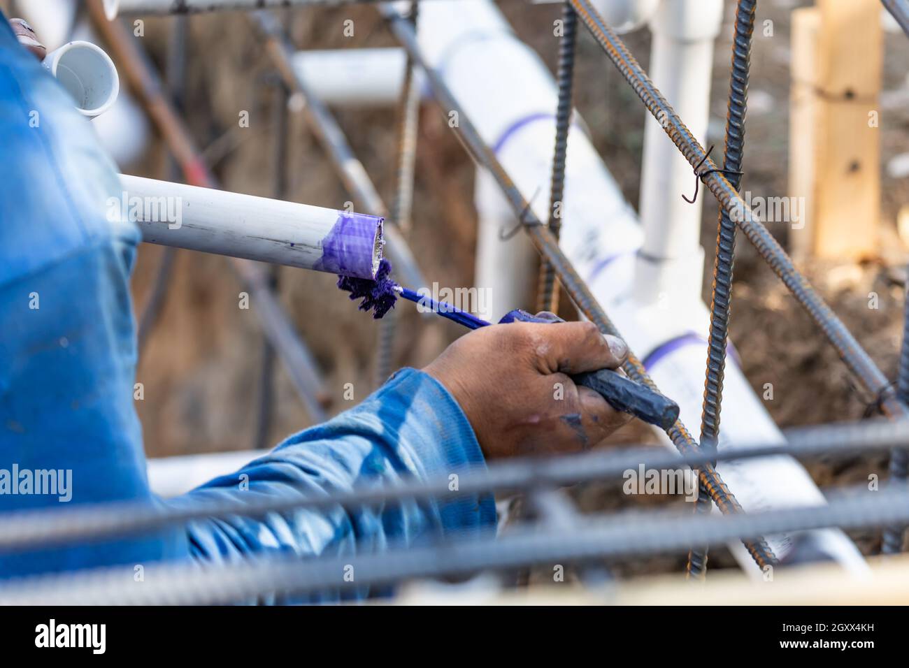 Plumber Applying Pipe Cleaner, Primer and Glue to PVC Pipe At