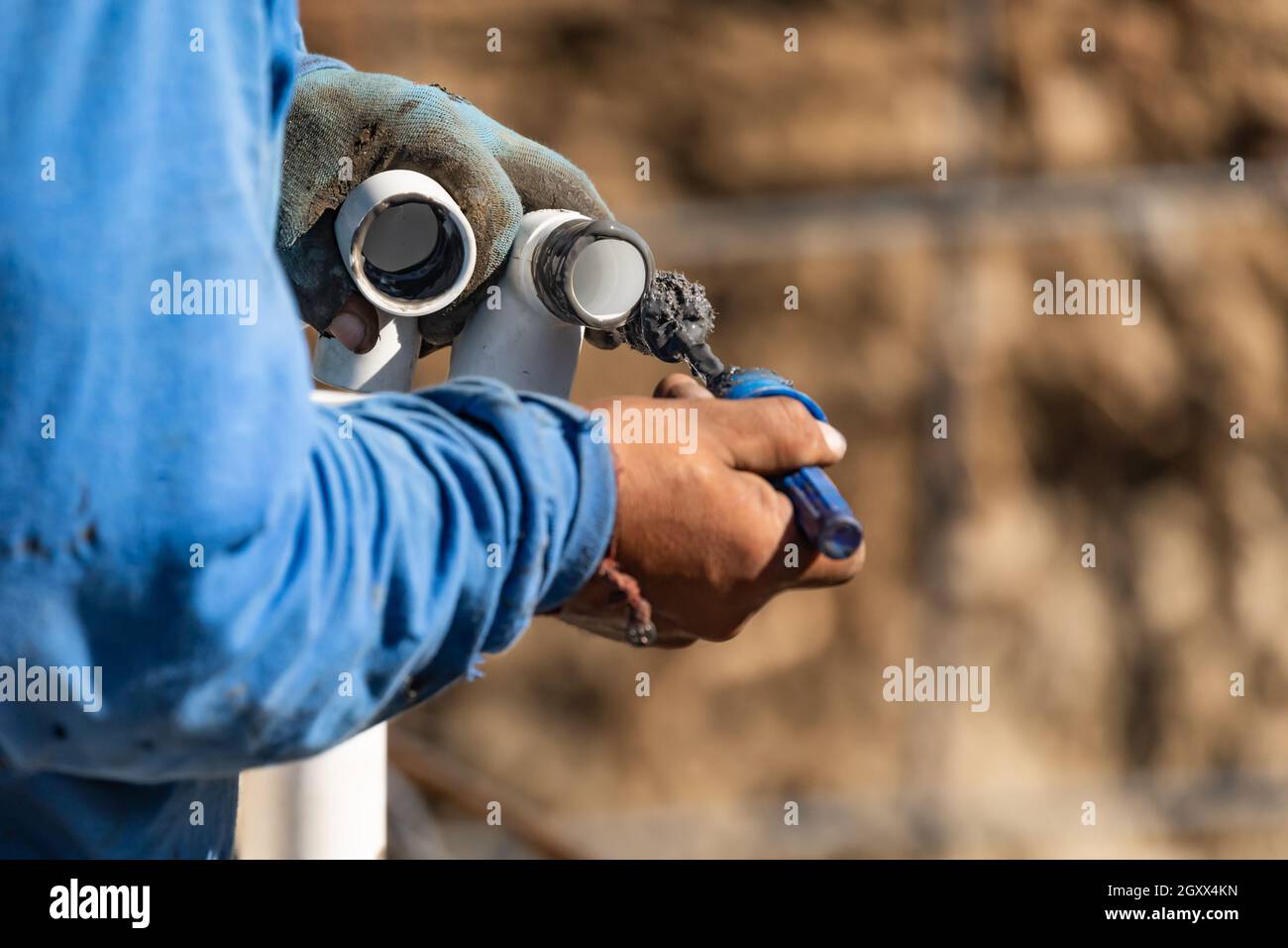 Plumber Applying Pipe Cleaner, Primer and Glue to PVC Pipe At