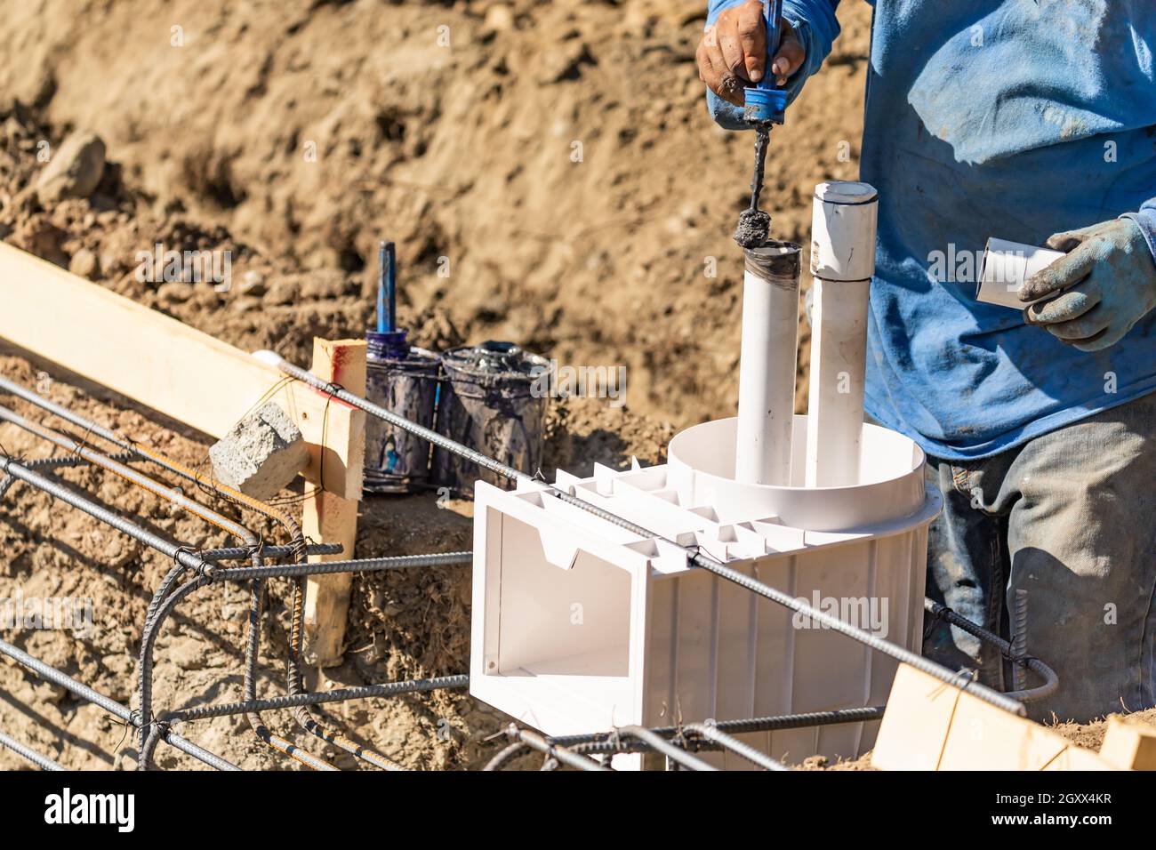 Plumber Applying Pipe Cleaner, Primer and Glue to PVC Pipe At