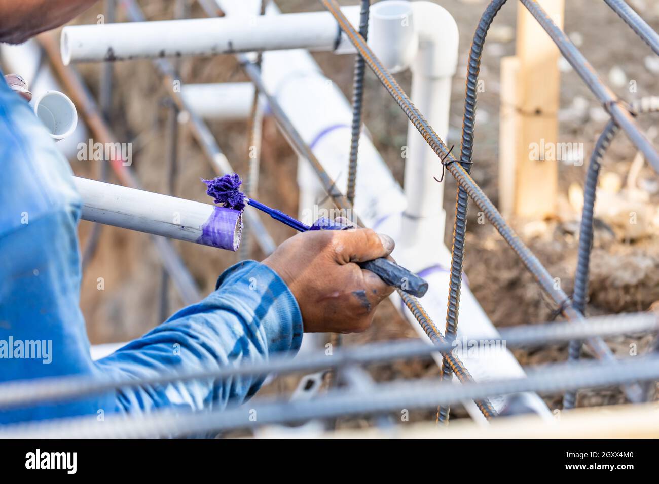 Plumber Applying Pipe Cleaner, Primer and Glue to PVC Pipe At