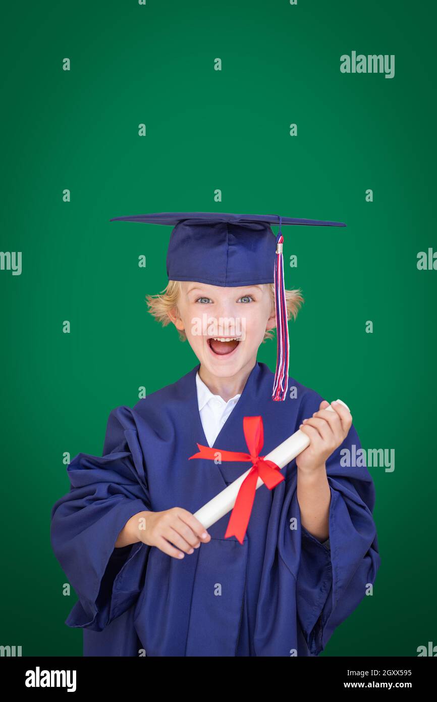 Portrait of graduate teen latin boy student in black graduation gown with  hat, holding diploma - isolated on background. Child back to school and  educational concept. Stock Photo