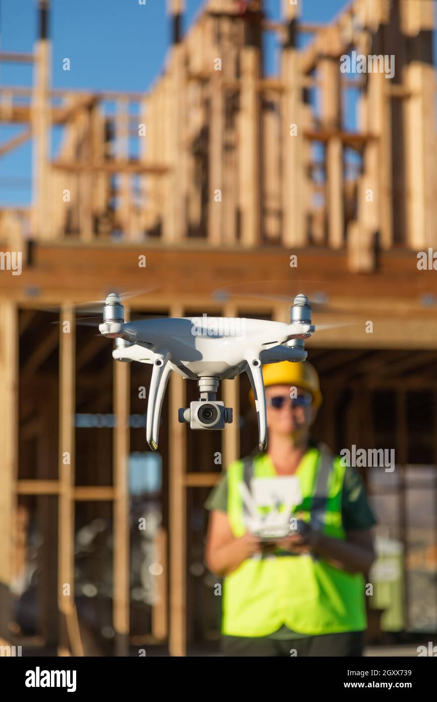 Female Pilot Flies Drone Quadcopter Inspecting Construction Site. Stock Photo