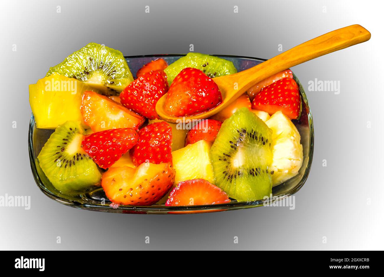 fresh fruit macedonia cut into cubes, Isolated gradient background with spoon Stock Photo