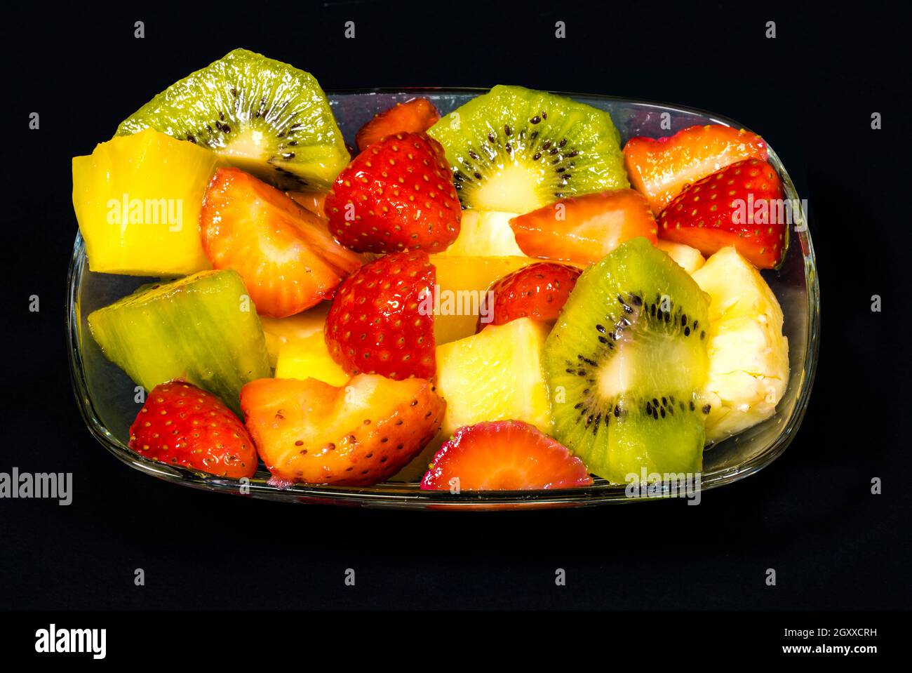 fresh fruit macedonia cut into cubes, Isolated background in black Stock Photo