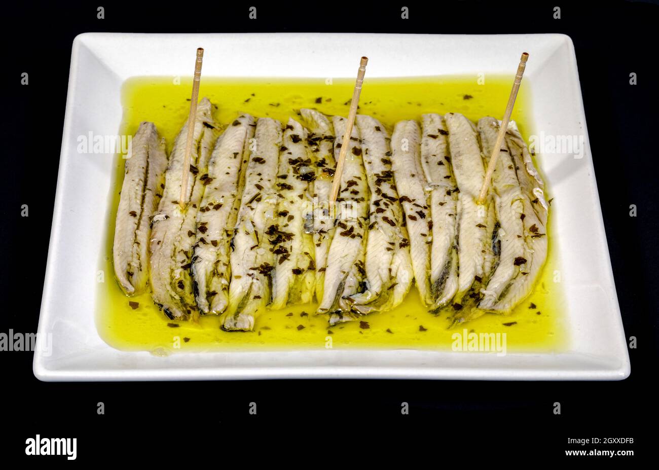 a pile of anchovies in vinegar isolated on a black background Stock