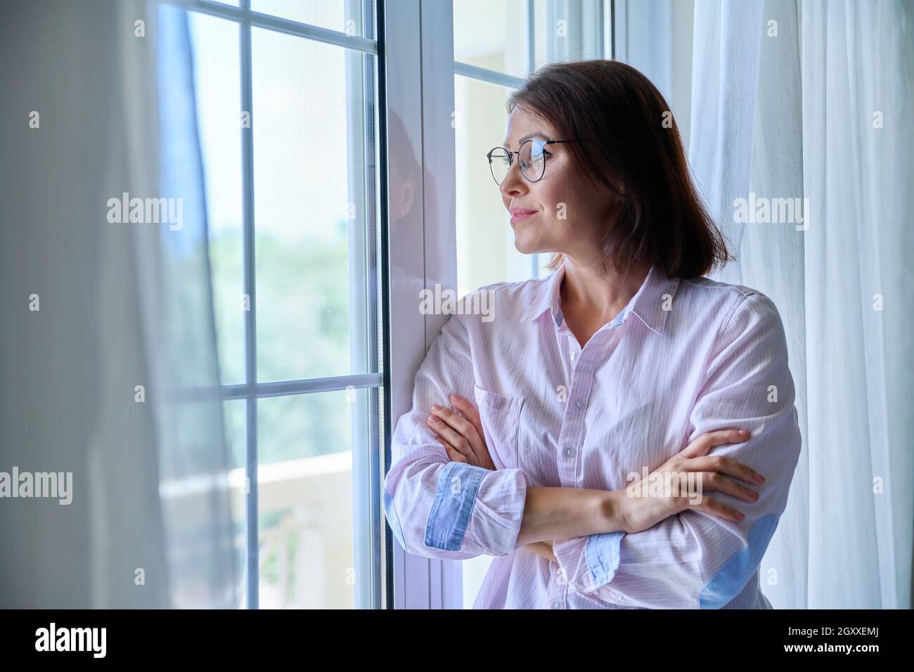Portrait of a mature confident woman looking out the window Stock Photo