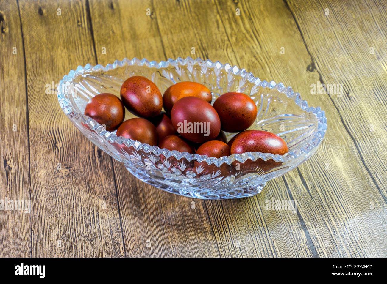 Painted Easter eggs in a crystal vase. Red painted chicken eggs for easter. Stock Photo