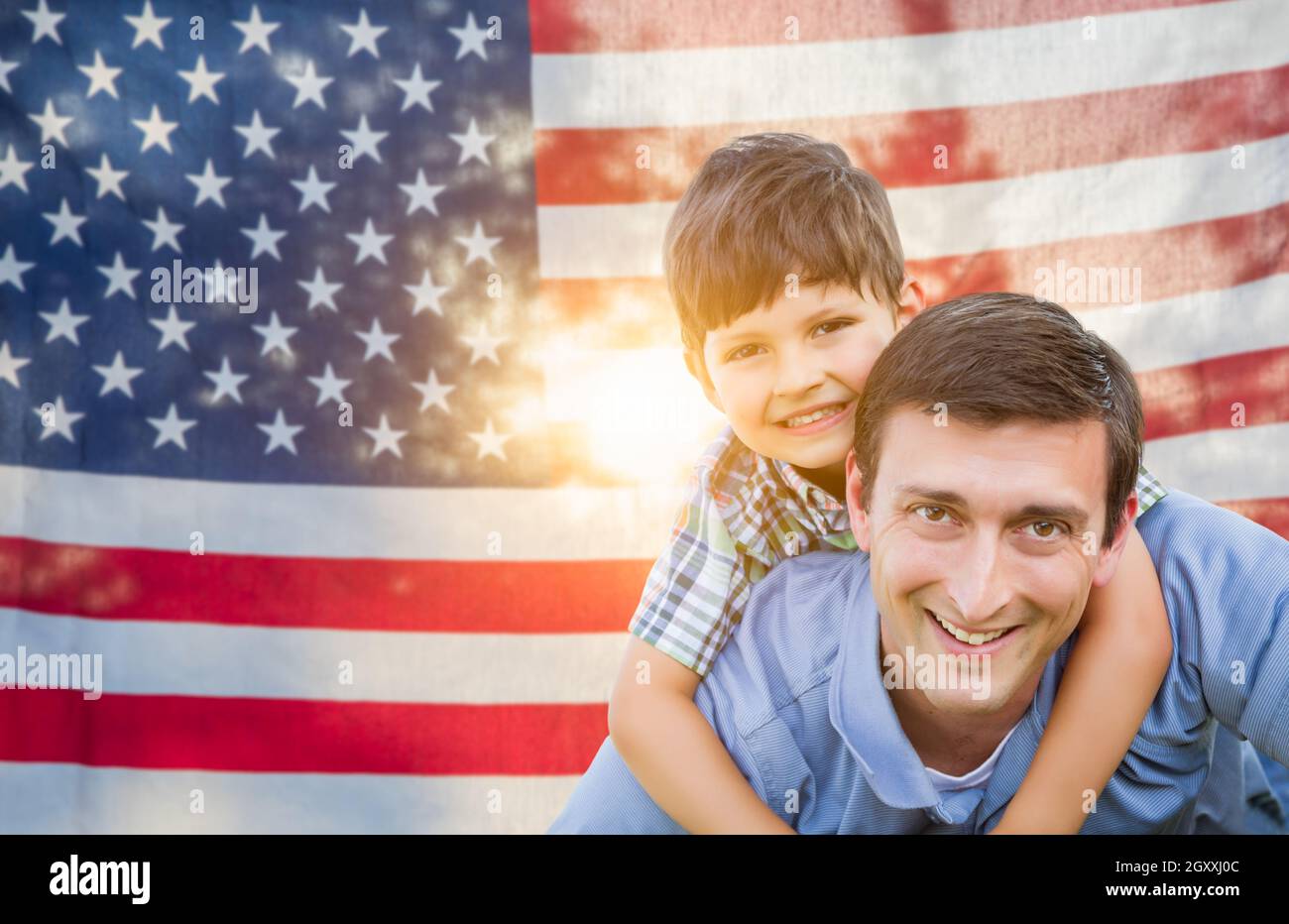 Father with Son Piggy Back Riding In Front of American Flag Stock Photo