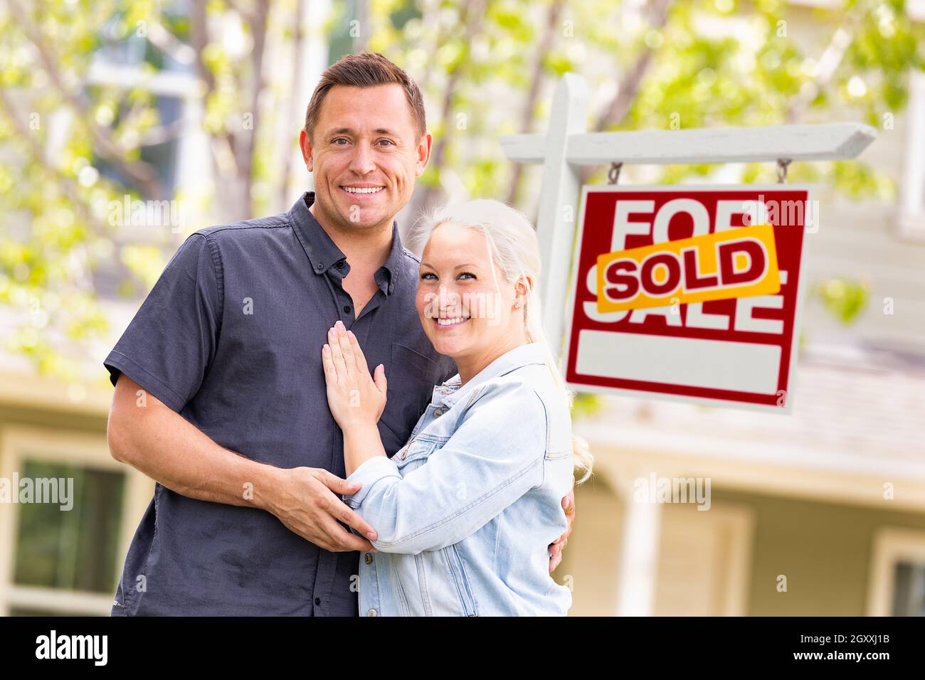 Caucasian Couple in Front of Sold Real Estate Sign and House Stock ...