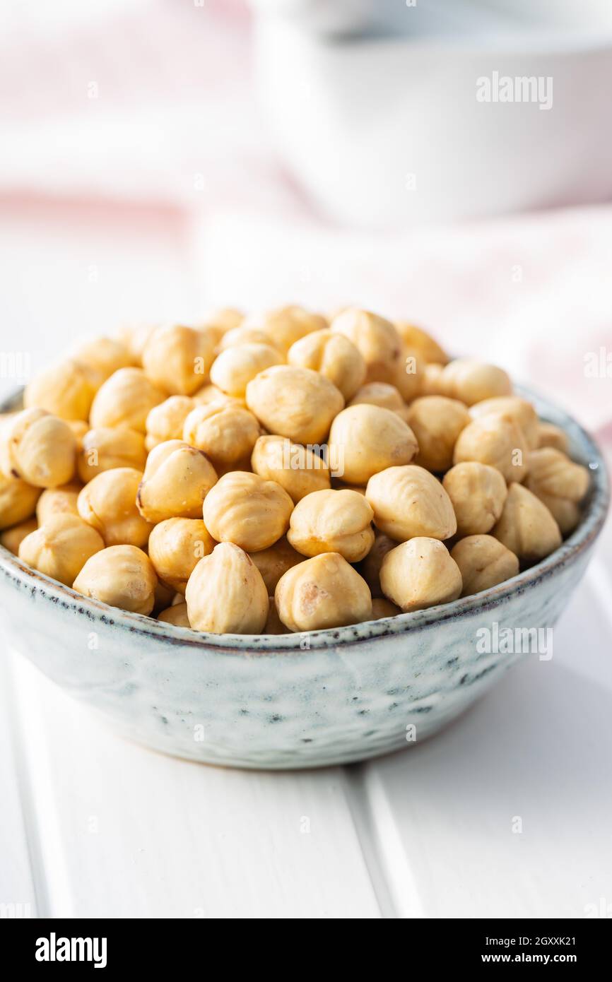 Peeled roasted hazelnut kernels in bowl. Stock Photo