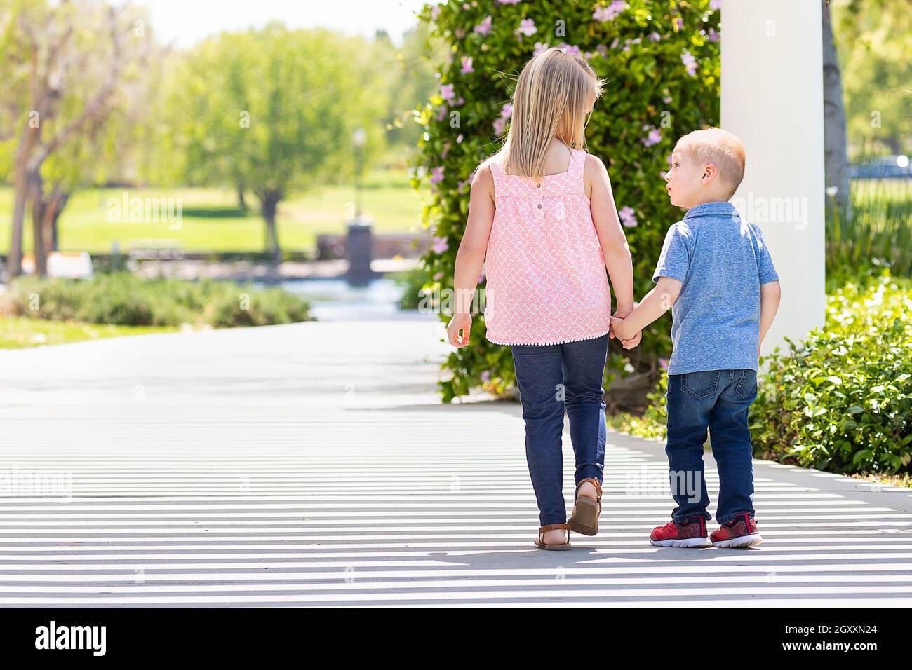 Young Sister and Brother Holding Hands And Walking At The Park Stock ...
