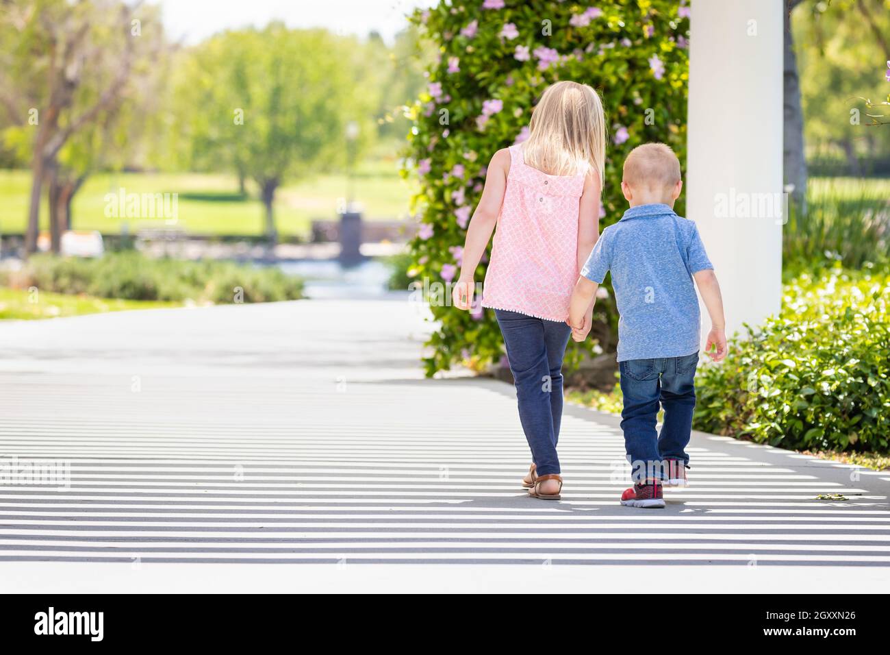 Young Sister and Brother Holding Hands And Walking At The Park Stock ...
