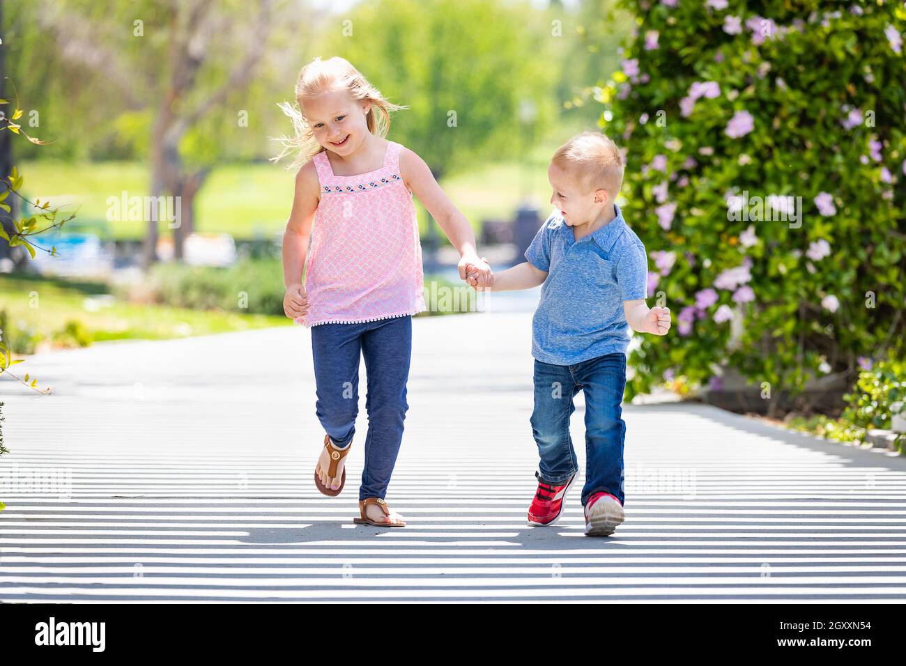 Young Sister and Brother Holding Hands And Running At The Park Stock ...