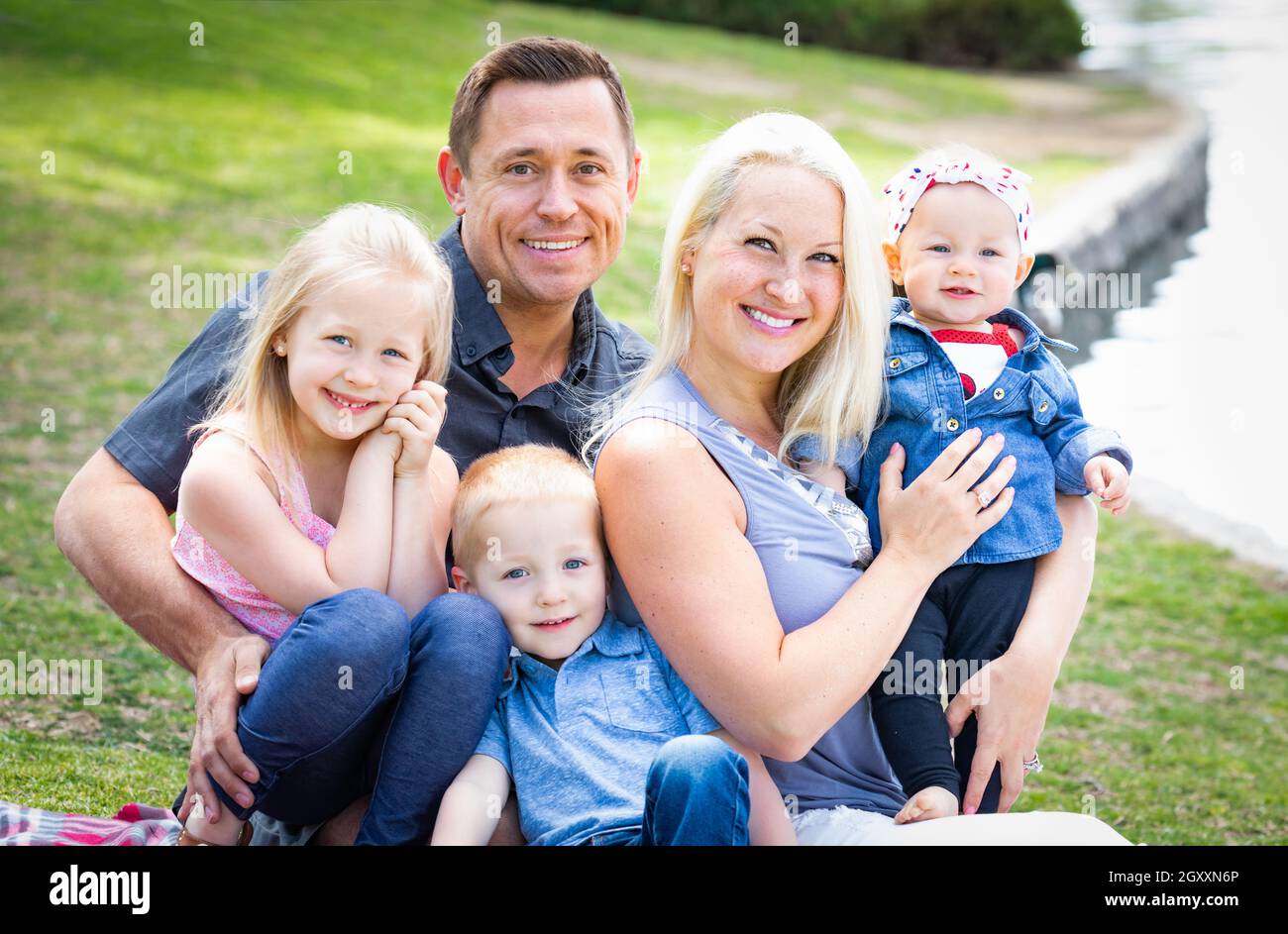 Happy Young Caucasian Family Portrait In The Park Stock Photo - Alamy