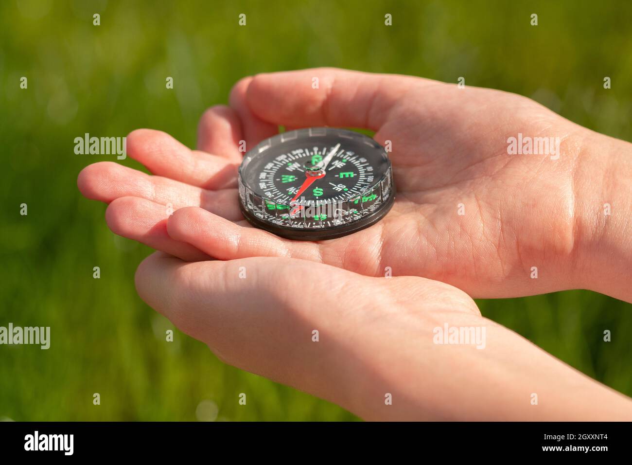 Old classic navigation compass on a children's hands. How to navigate