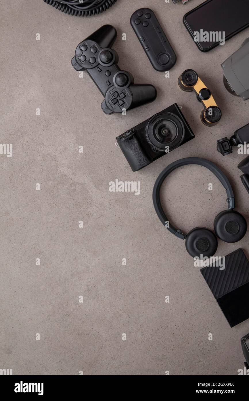 Overhead flat lay of black technology devices and gadgets on a grey background Stock Photo