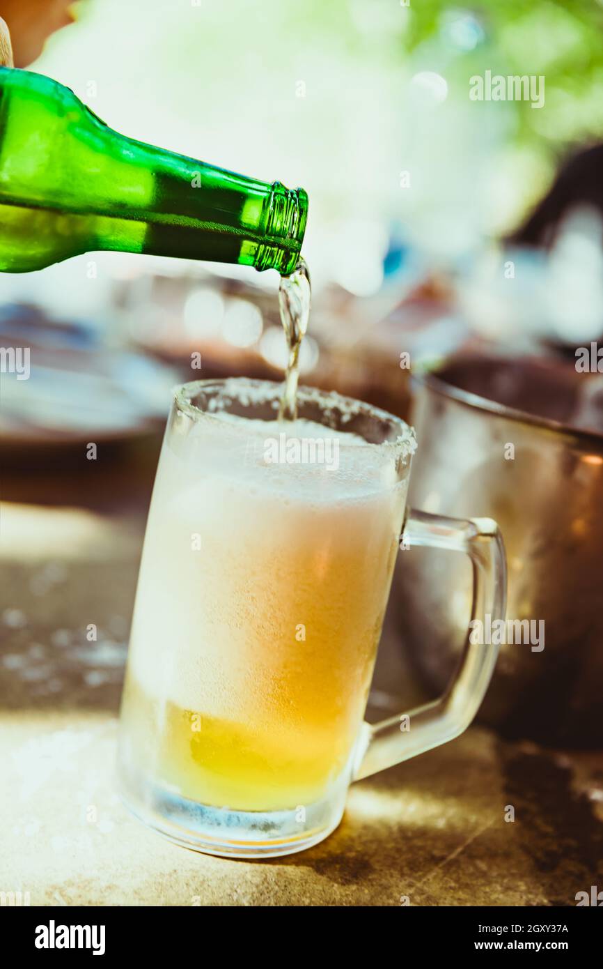 Foamy Beer. Glass of Light Beer. Pouring into the Mug. Glass Full of Foam. Cold Beer on the Table. Evening in the Pub. Beer is Always Good Idea. Stock Photo