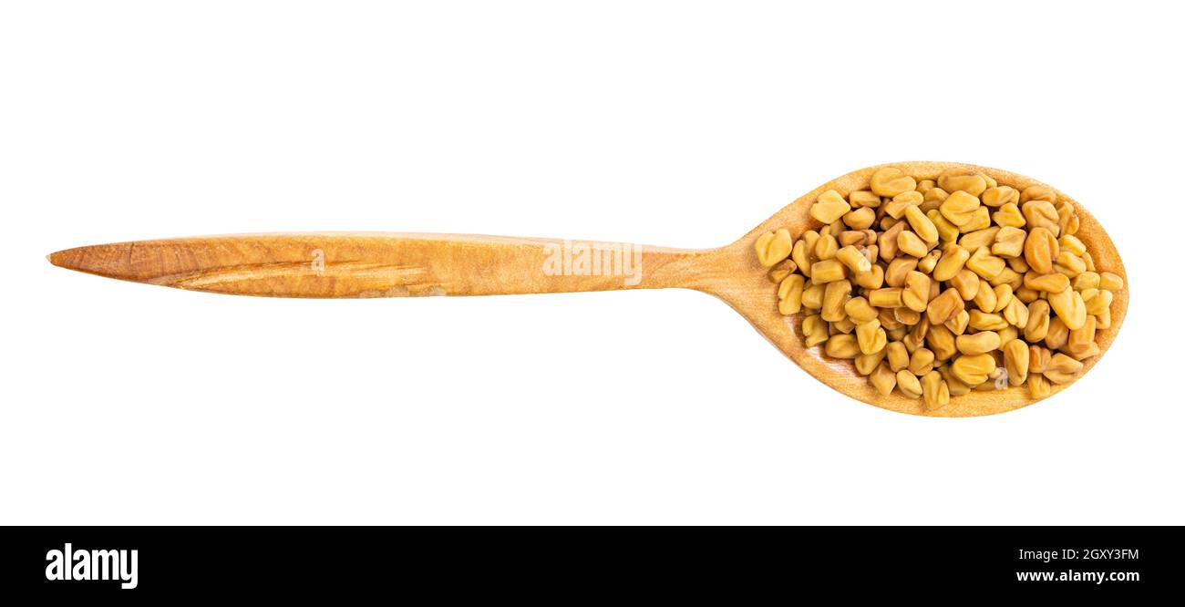 top view of wood spoon with fenugreek seeds isolated on white background Stock Photo