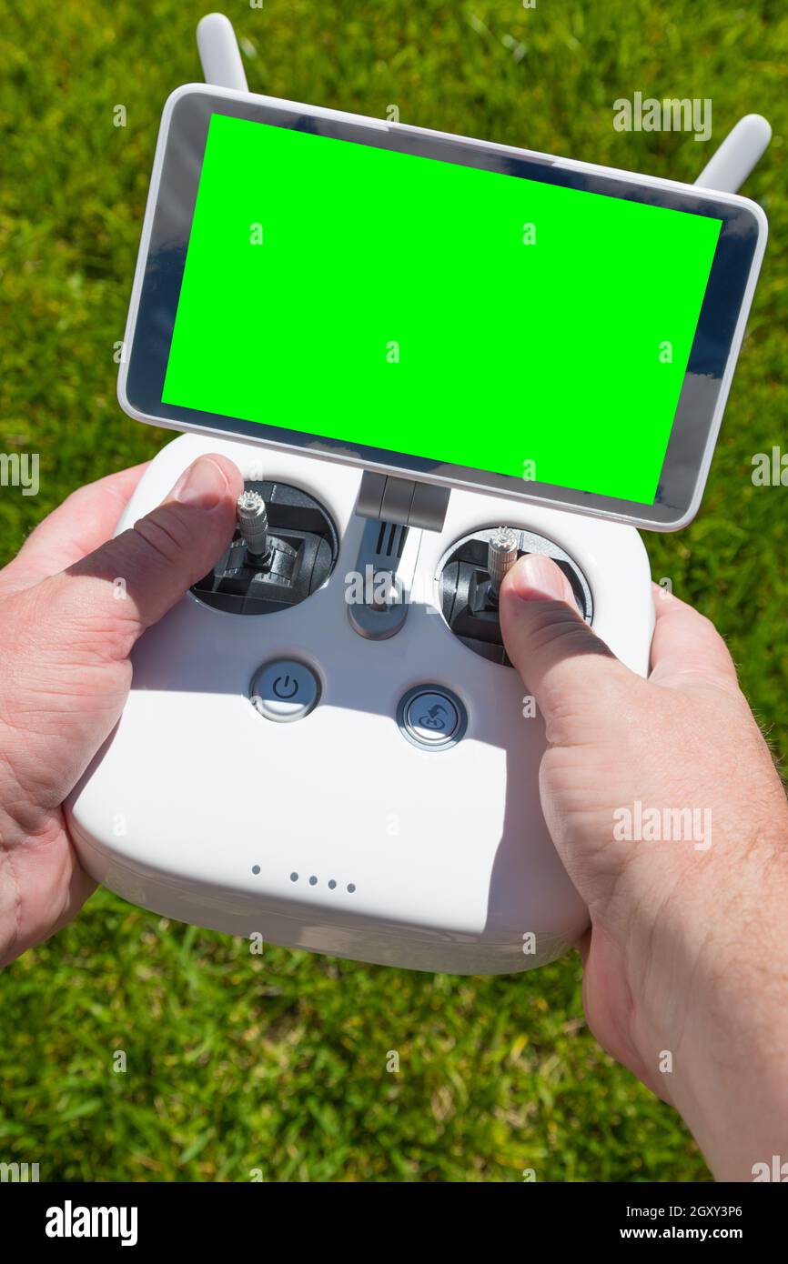 Hands Holding Drone Quadcopter Controller With Blank Green Screen. Stock Photo