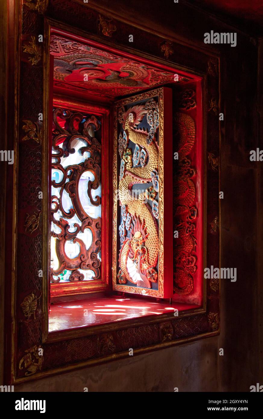 Carved shutters in an oriental temple. Richly decorated shutters with dragon theme, Chinese Buddhist monastery. Stock Photo