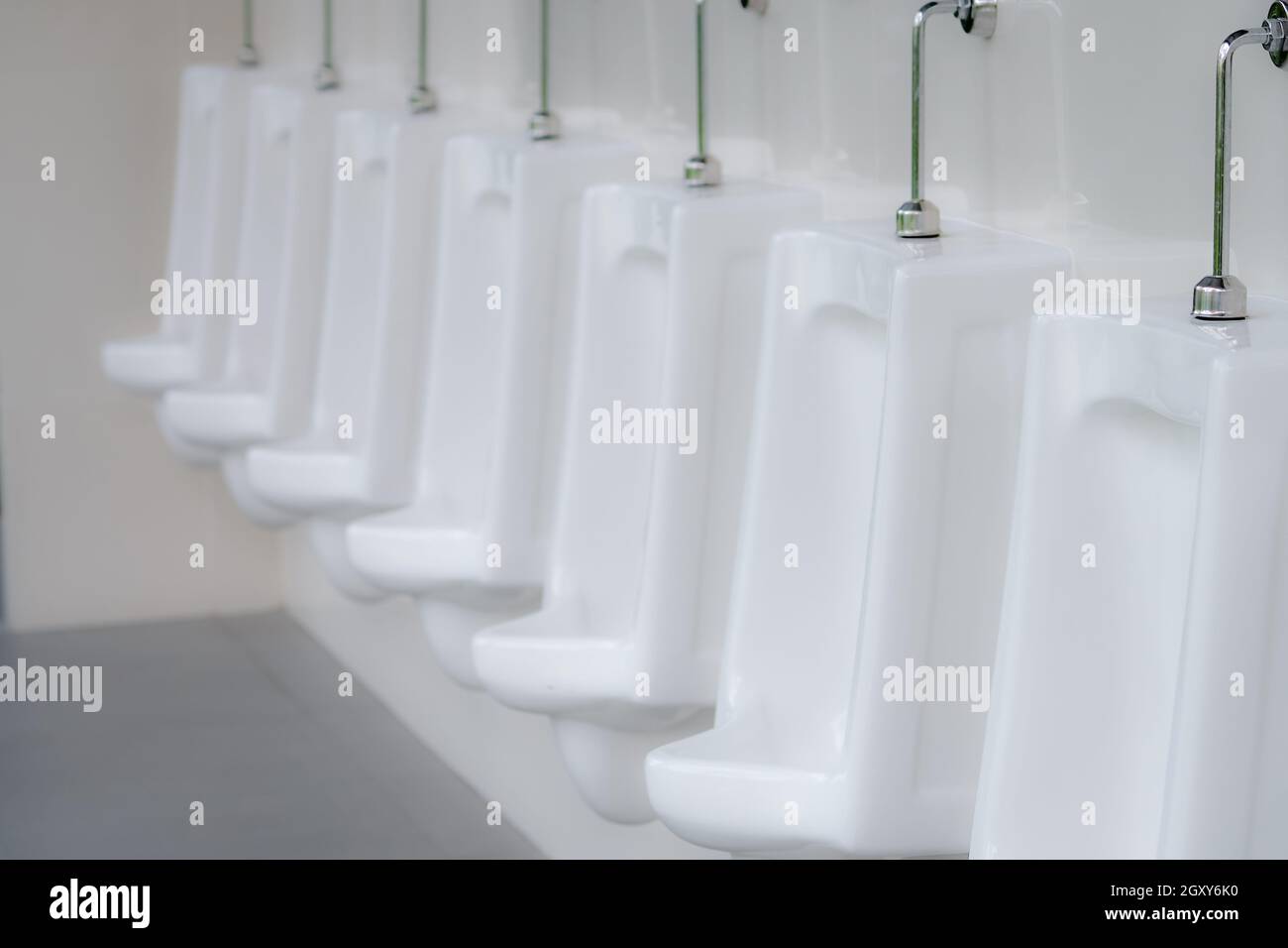 White urinals in men public toilet. Ceramic urinals in a row in men